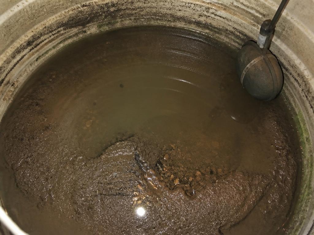 Dirty water tank interior before cleaning with sludge, sediment and wall deposits